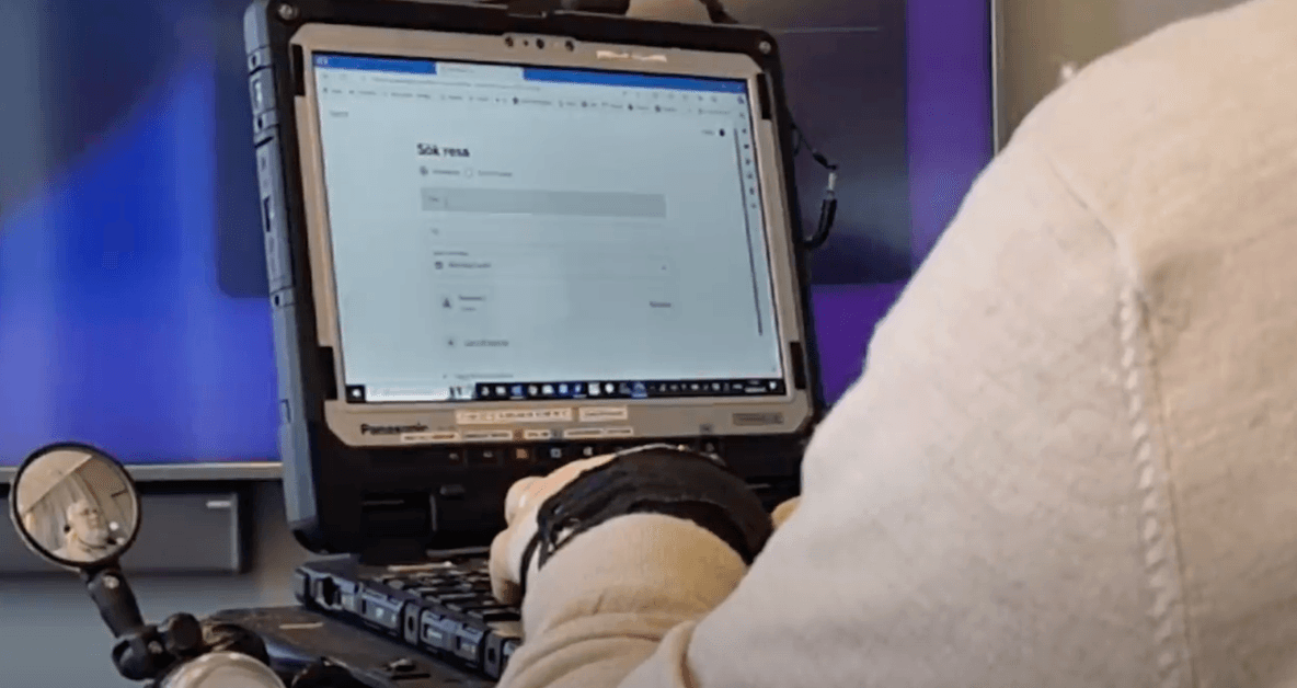 Person using a rugged laptop mounted in a vehicle.